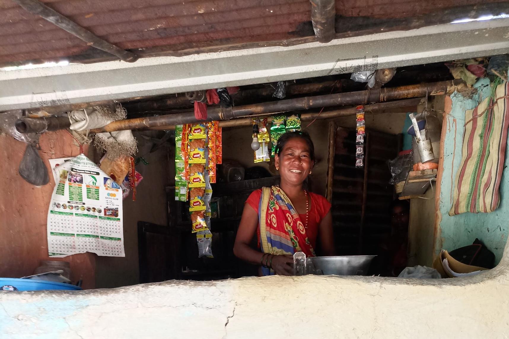 A Katuwaghat female villager smiling with her food stand.
