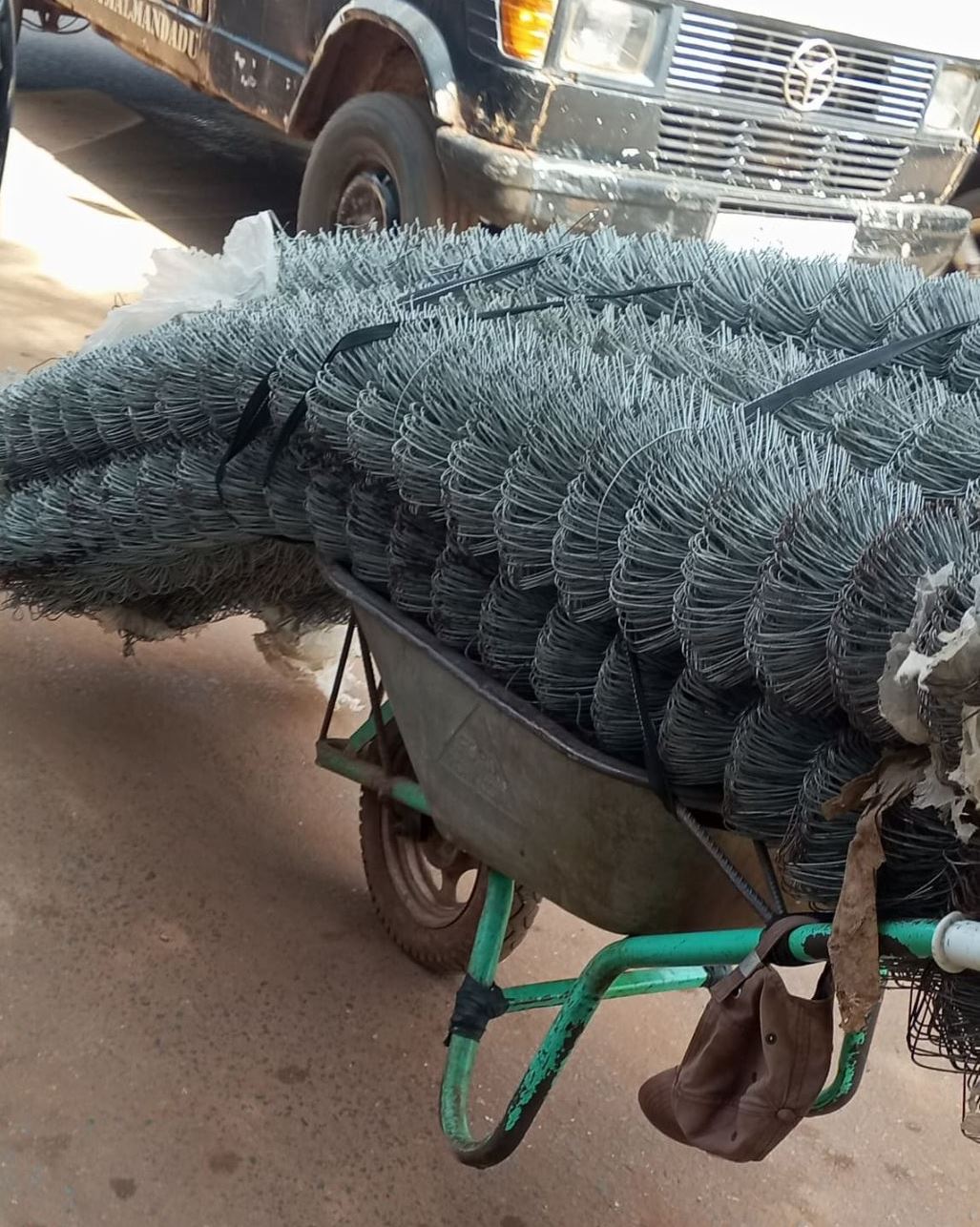 A wheelbarrow holding three large bundles of wire net for Nihoma's community garden.