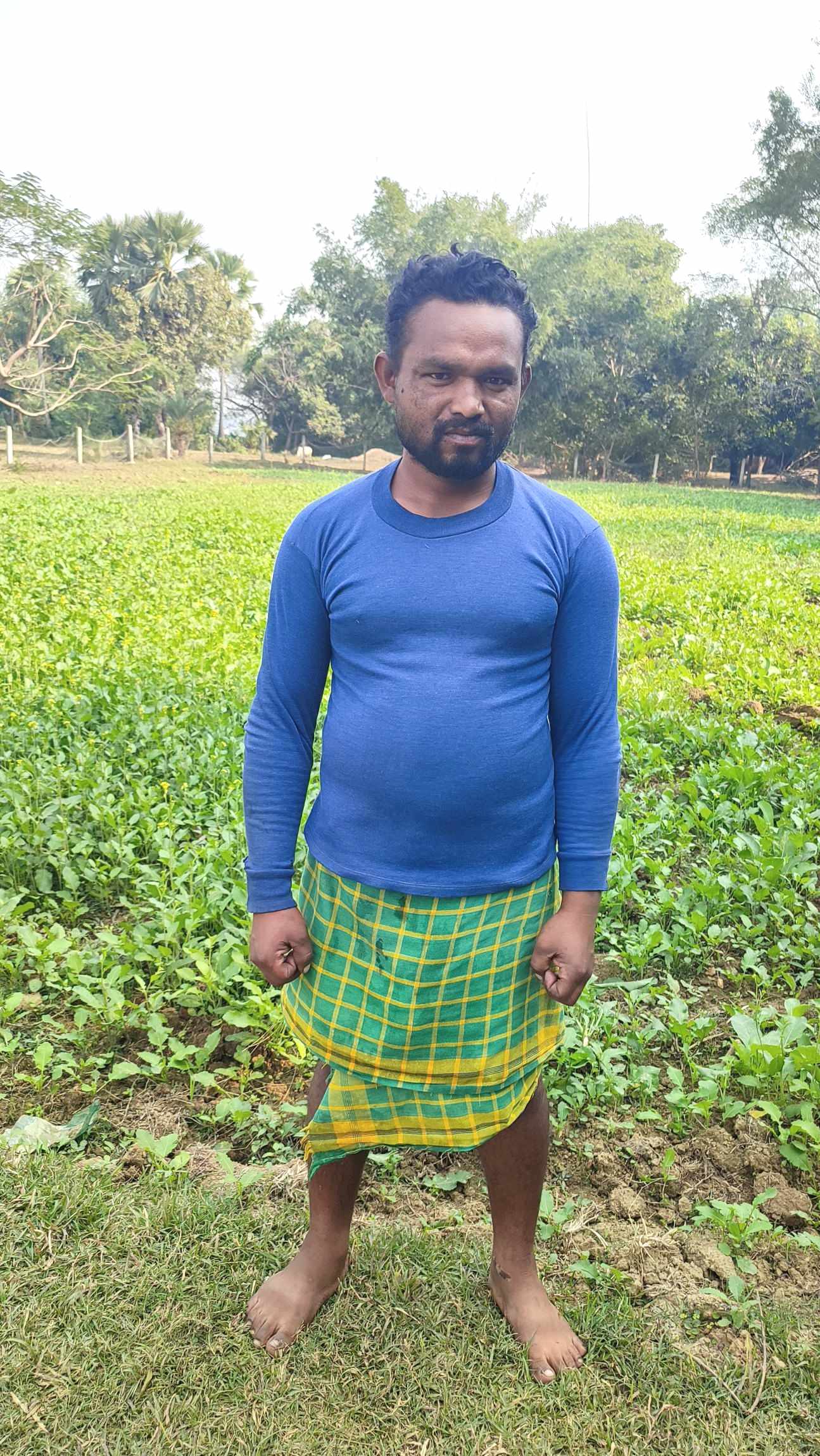 Baromasia male villager, Kalesor, standing in front of his mustard field.