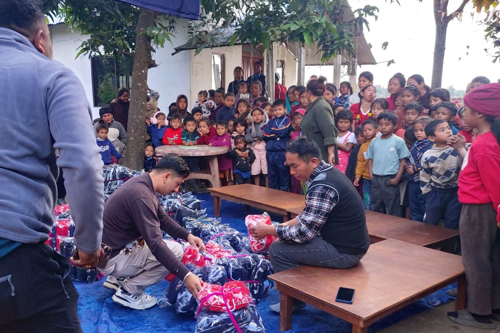 TCD giving clothes to the children for the cold weather.