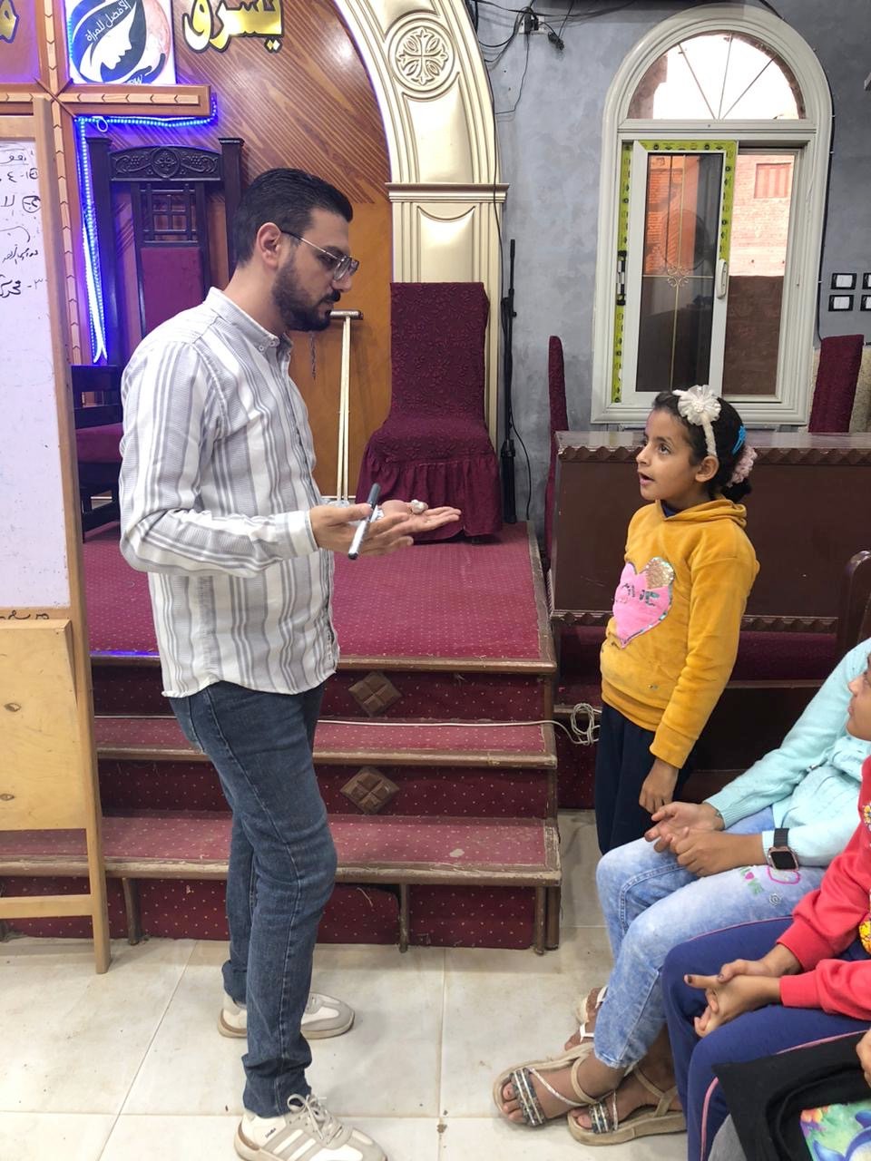 A TCD teacher talking with a young girl at the Upper Egypt Village Cluster in Egypt.