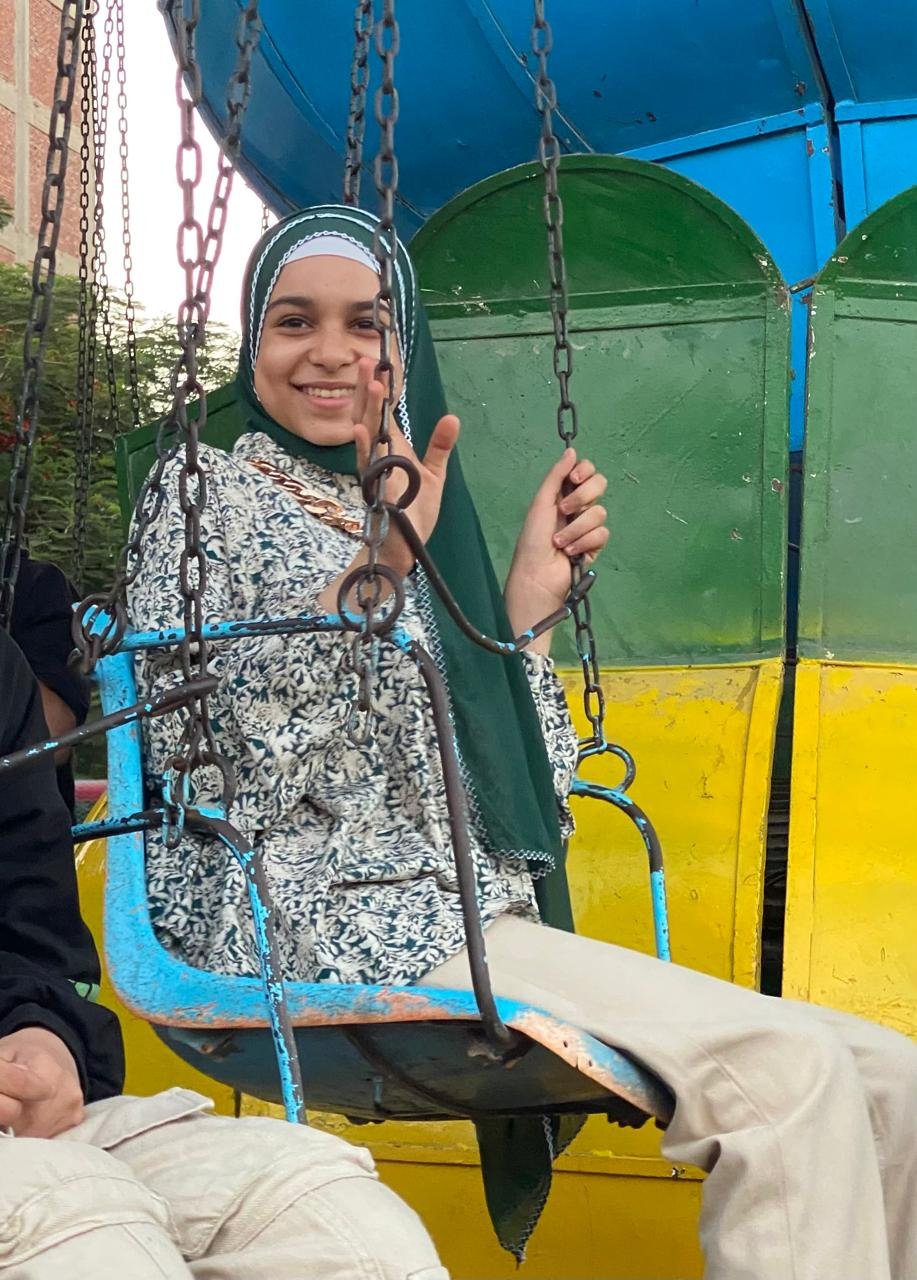 Egyptian teenager, Yazmin, riding a merry-go-round swing.