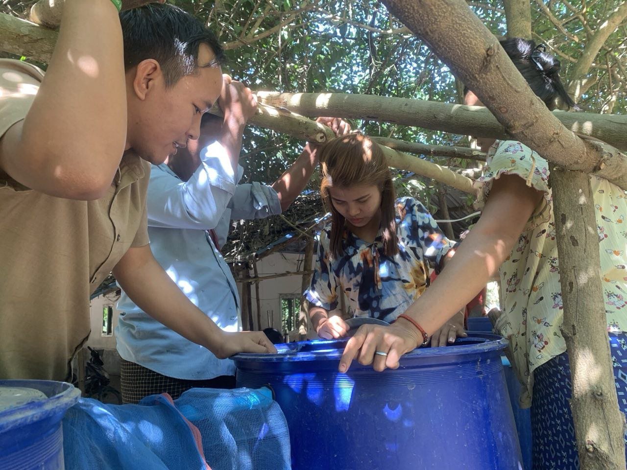Myanmar villagers working on their newly installed biosand filtration system.