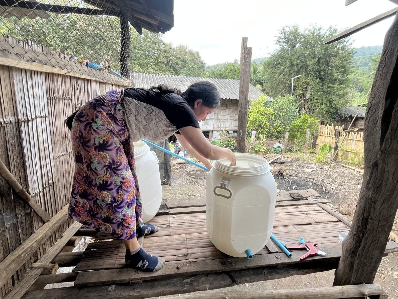 A Ratchaboot female villager working on a biosand filtration system.